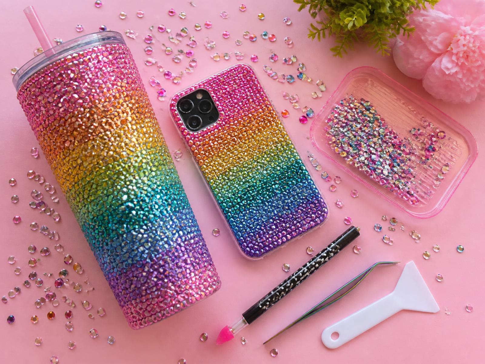 Finished rhinestone tumbler and phone case with loose gems, applicator pen, tweezers and spatula